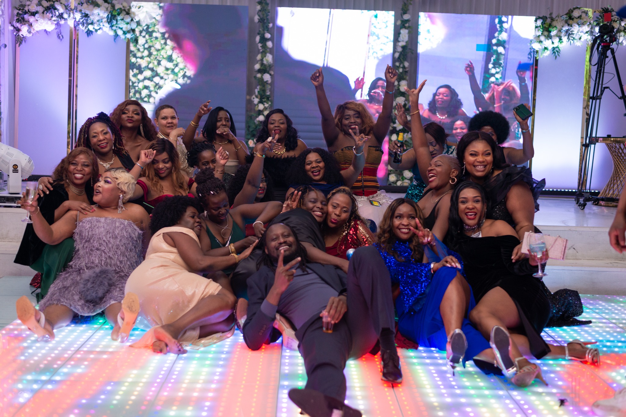 Guests celebrating together on the illuminated dance floor at the 2024 Grille Community Christmas Gala