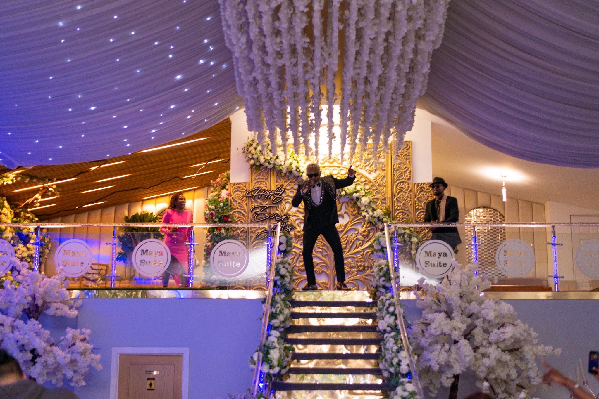 A performer framed by the Maya Suite staircase at the 2024 Grille Community Christmas Gala