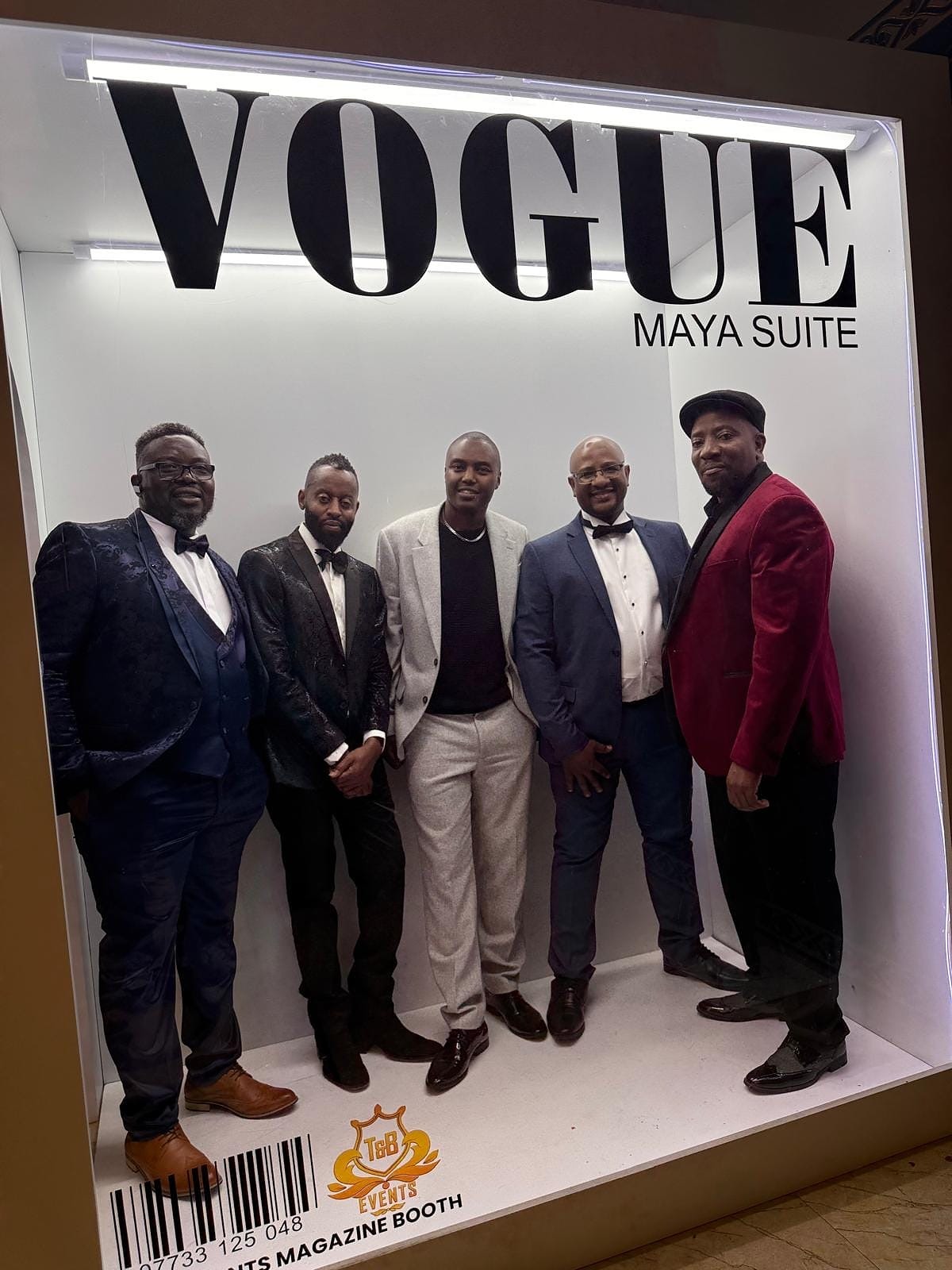 A group of gentlemen posing at the Maya Suite Vogue photo area at the 2024 Grille Community Christmas Gala