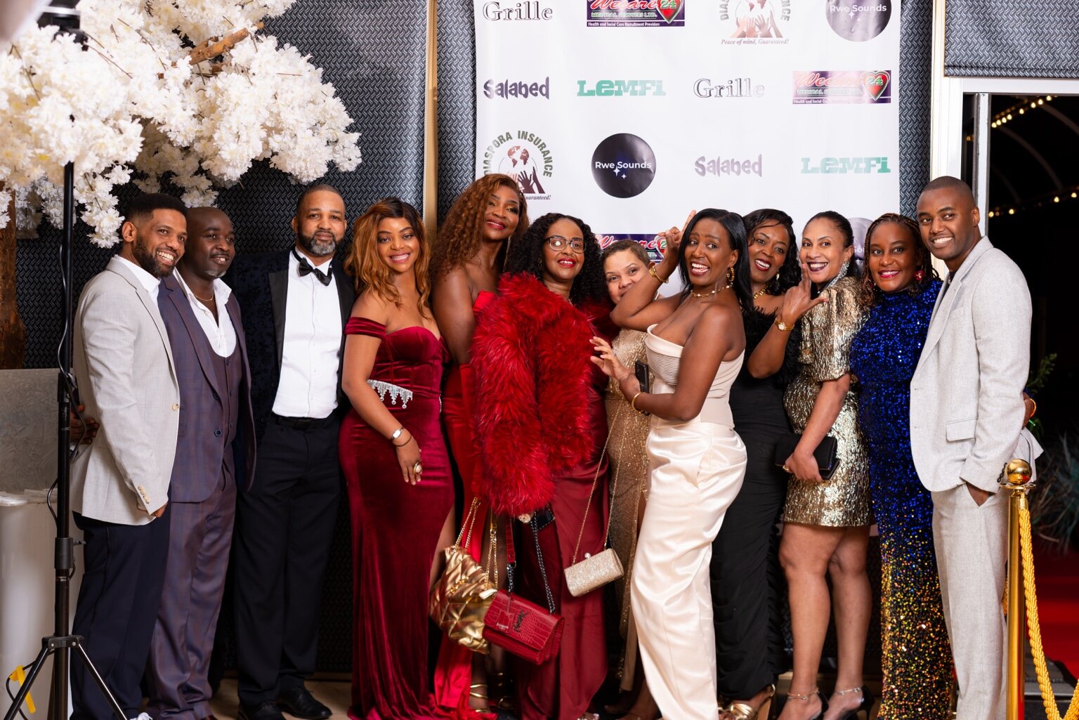 Guests posing together beside the gala red carpet at the 2024 Grille Community Christmas Gala